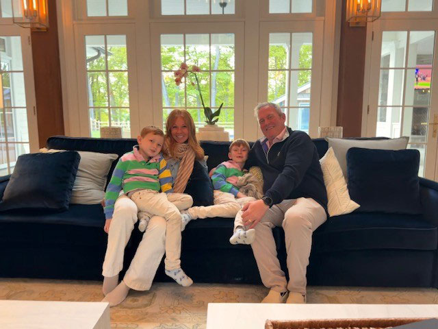 Jessica-and-Dr-Michael-Zampieri-pic-1 | NJ Sharing Network Family of four sits on a dark blue sofa in a bright living room, smiling at the camera.