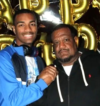 Jordan-and-Sean-Greene-for-web-2 | NJ Sharing Network Two men pose for a photo at a party, with gold balloons in the background and one man touching the other's chest for a friendly pose on the left.