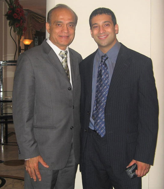 Sham-Karnani-and-Rajesh-Karnani-for-web | NJ Sharing Network Two men in suits smile for the camera while standing indoors at a formal event venue.