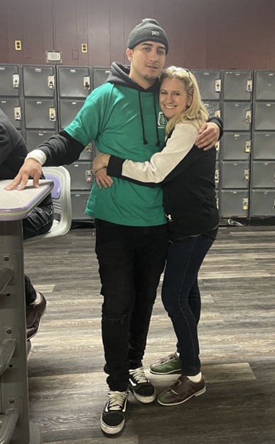 Gene-Patrick-Coppola-Jr-and-mother-Christina | NJ Sharing Network Two people hug and smile at the camera in a bowling alley, with lockers behind them; man in a green shirt and beanie, woman in a black vest and jeans.