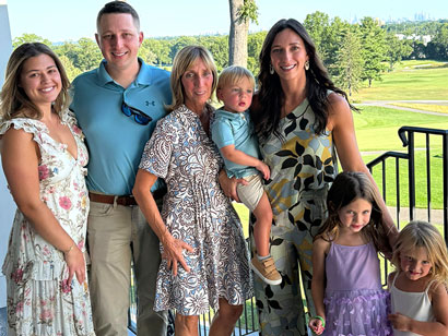 John-Levine-Fund-Golf-Event-3 | NJ Sharing Network Family of seven posing on an outdoor balcony, smiling, with a sunny green park behind them.